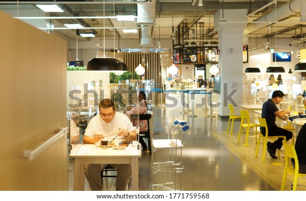 Bangkok/Thailand -\
June 26, 2020: New Normal, Physical & social distancing\
measure in food hall after Covid-19 pandemic lockdown. Clear\
divider / barrier on table\
installed.