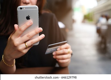 Bangkok,Thailand  - May 14,2017 :close up asian woman hand using iphone mobile device for pay online with credit card concept.