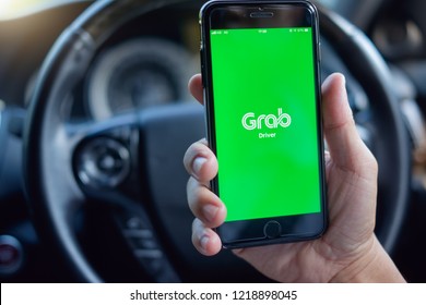 BANGKOK,THAILAND - NOV 02,2018 : Asian Man Holding IPhone 6 Plus, Using Grab Driver App Inside The Car, Grab Is Smartphone App-based Transportation Network, Reliable Private Hire Car Hailing Service