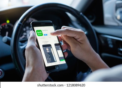 BANGKOK,THAILAND - OCT 30,2018 : Young Asian Man Holding Apple IPhone 6 Plus, Download And Install Grab Driver App From App Store Inside The Car, Grab Is Smartphone App-based Transportation Network