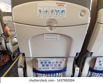 Bangkok,Thailand-Circa June 2019:Seat pocket sets up in domestic day flight of Bangkok Airways putting the informative safety instructions and magazine.Seats at around exit show how to open door. 