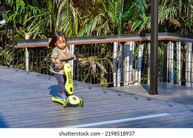 BANGKOK,THAILAND-FEBRUARY 23,2020 : Unidentified Asian Kid Enjoy Playing And Riding Scooter Without Using Any Safety Gear In Home On Riverside Terrace At Hidden Woods. Active Sport For Preschool Kid.