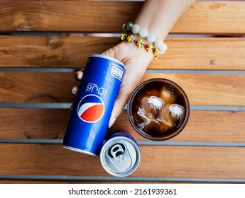 BANGKOK-THAILAND-MAY-29-2022 : Woman Hand With  Pepsi Cola Softdrink Can And A Glass Of Pepsi, A Carbonated Soft Drink Produced And Manufactured By Pepsi In Thailand