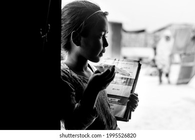Bangladesh – March 06, 2021: A village young girl student Nabiha 15, holding some books and looking away at Majherchor, Chandpur, Chittagong.