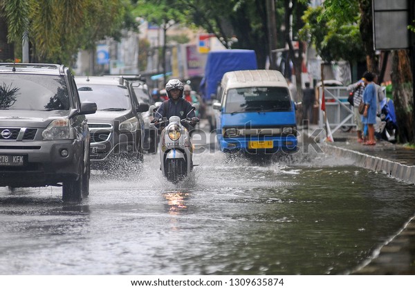 Banjarmasin,
South Kalimantan, Indonesia, 11 - February 2019: It was raining
several hours in the flooded city of Banjarmasin, seen by several
motorbike riders and cars passing the
flood.