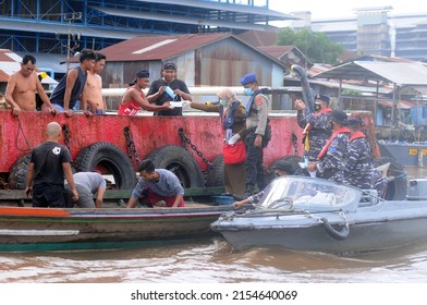 Banjarmasin, South Kalimantan, Indonesia - February 8, 2021: The Banjarmasin City Covid 19 Joint Task Force Team Distributes Masks To Coastal Residents Using Boats