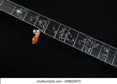Banjo. Mahogany banjo luxury gold inlaid with mother of pearl on a black background.