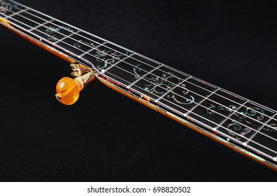 Banjo. Mahogany banjo luxury gold inlaid with mother of pearl on a black background.