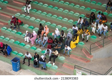 BANJUL, THE GAMBIA - FEBRUARY 10, 2022 View Of Students Sitting On Green Seats Waiting For A Bus Viewed From Arch 22