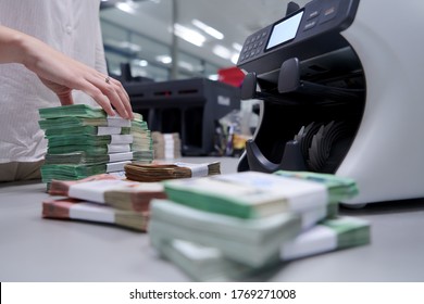Bank employees using money counting machine while sorting and counting paper banknotes inside bank vault. Large amounts of money in the bank - Shutterstock ID 1769271008