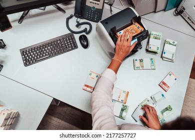 Bank Employees Using Money Counting Machine While Sorting And Counting Paper Banknotes Inside Bank Vault. Large Amounts Of Money In The Bank