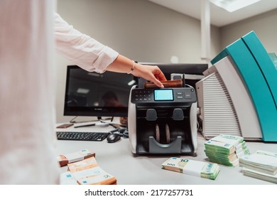 Bank Employees Using Money Counting Machine While Sorting And Counting Paper Banknotes Inside Bank Vault. Large Amounts Of Money In The Bank