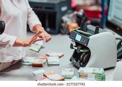 Bank Employees Using Money Counting Machine While Sorting And Counting Paper Banknotes Inside Bank Vault. Large Amounts Of Money In The Bank