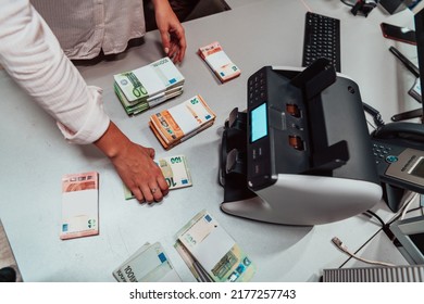 Bank Employees Using Money Counting Machine While Sorting And Counting Paper Banknotes Inside Bank Vault. Large Amounts Of Money In The Bank