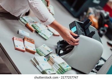 Bank Employees Using Money Counting Machine While Sorting And Counting Paper Banknotes Inside Bank Vault. Large Amounts Of Money In The Bank