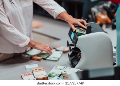 Bank Employees Using Money Counting Machine While Sorting And Counting Paper Banknotes Inside Bank Vault. Large Amounts Of Money In The Bank