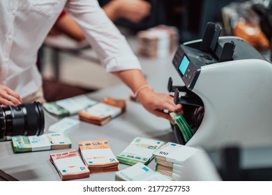 Bank Employees Using Money Counting Machine While Sorting And Counting Paper Banknotes Inside Bank Vault. Large Amounts Of Money In The Bank