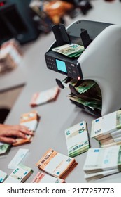 Bank Employees Using Money Counting Machine While Sorting And Counting Paper Banknotes Inside Bank Vault. Large Amounts Of Money In The Bank