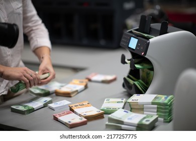 Bank Employees Using Money Counting Machine While Sorting And Counting Paper Banknotes Inside Bank Vault. Large Amounts Of Money In The Bank