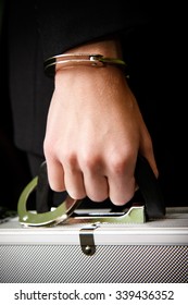 Bank finance security concept - businessman or guard hand  in handcuffs closeup holding suitcase with money Stock Photo