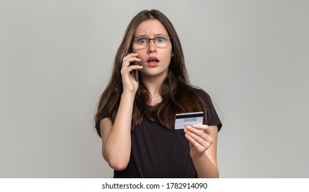 Bank fraud. Phone scam. Shocked woman checking credit card balance on phone isolated on gray. Payment security. Mobile verification. Personal data. Customer support.