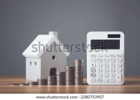 Bank interest for home, Interest rate for housing, Business and Financial for residence, Money saving for home concept. Increasing coin stacked and house model on the wooden table. Studio shot.