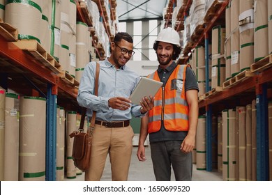 Bank Manager Showing Loan Options To Warehouse Manager Using Digital Tablet In Modern Factory 