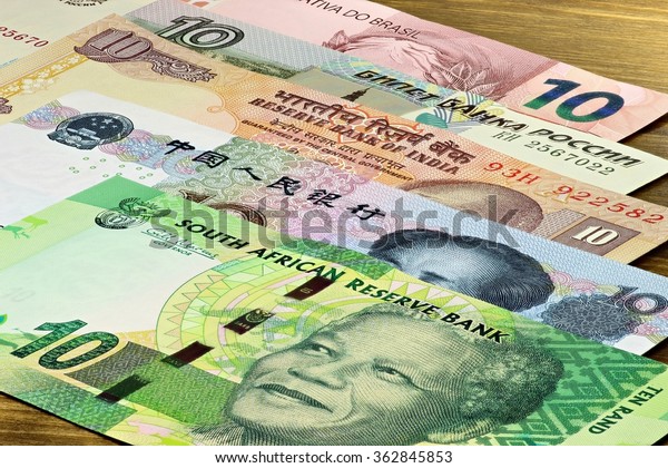 bank notes of the BRICS states on wooden background