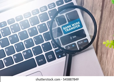 Bank Wire Transfer Word Written On Keyboard View With Magnifier Glass