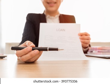 The banker handed the pen for signing in loan document and agreement. Loan concept.