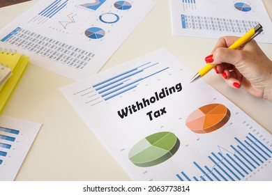 Banker present to the phrase Withholding Tax on the chart sheet.  - Shutterstock ID 2063773814