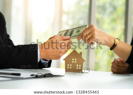Banker receiving deposit payment by dollars cash from buyer who signed loan or mortgage agreement with bank before investor become land owner with monthly payment term and condition deal with interest