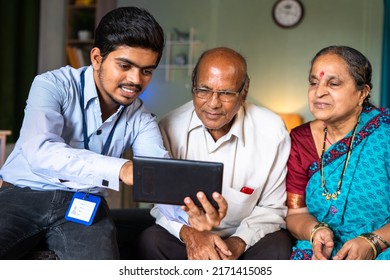 Banker Showing Insurance Or Financial Replated Plans On Digital Tablet To Senior Couple At Home - Concept Of Financial Support, Retirement Goal And Banking