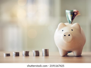 . Banking, Accounting And Financial Management To Plan For The Future, Collect A Rainy Day Fund And Profit. Piggybank, Saving And Finance With Money, Coins And Cash In A Coin Bank On A Table At Home