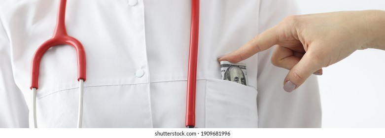 Banknote Is Thrust Into Doctor's Pocket. Bribery In Medicine Concept