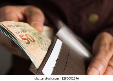 Banknotes Of Brazilian Currency: Reais. Brazil Money. Front View Senior Person Holding Bills.