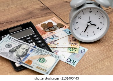 Banknotes And Coins Of The Republic Of Belarus, One Hundred US Dollars, An Alarm Clock And A Calculator On A Wooden Background. Belarusian Monetary Inflation. Time To Change Money. Dollar To Ruble.