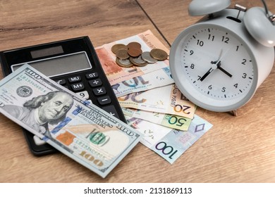 Banknotes And Coins Of The Republic Of Belarus, One Hundred US Dollars, An Alarm Clock And A Calculator On A Wooden Background. Belarusian Monetary Inflation. Time To Change Money. 