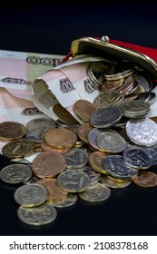 Banknotes And Coins Of The Russian Federation Rubles And Kopecks Are Scattered From A Red Wallet On A Black Background. Inflation Concept - Money Doesn't Fit In Wallet