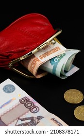 Banknotes And Coins Of The Russian Federation Rubles And Kopecks Are Scattered From A Red Wallet On A Black Background. Inflation Concept - Money Doesn't Fit In Wallet