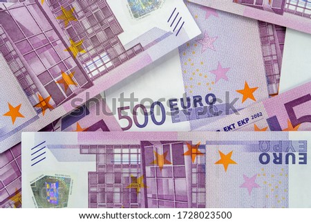 Banknotes of five hundred and 500 euros are scattered in a chaotic manner. European currency lies on the table. Blank for design, background. View from above.