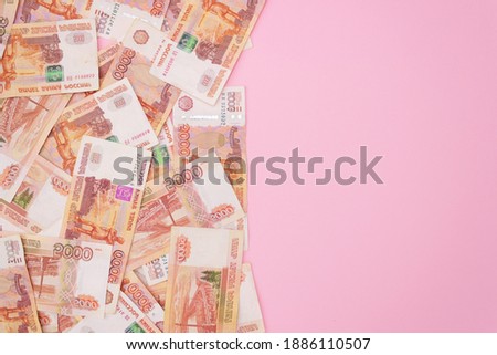 banknotes of russian rubles with a face value of five thousand, pink background, free space for text. The view from the top. Money