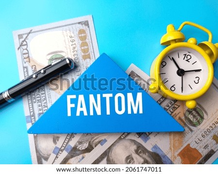Banknotes,clock,pen and wooden puzzle written with text FANTOM.
