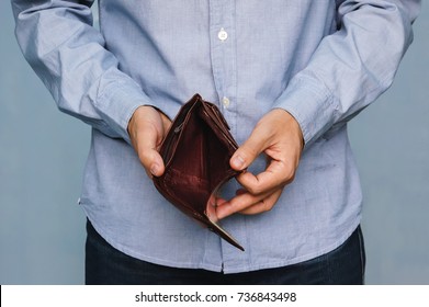 Bankruptcy - Business Person holding an empty wallet. Man showing empty wallet by showing the inconsistency and lack of money and not able to pay the loan and the mortgage.
