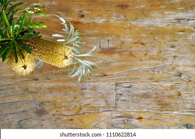 Banksia Australian Native Flower On Natural Wood Background, Wild Flowers With Leaves. Botanical Arrangements.