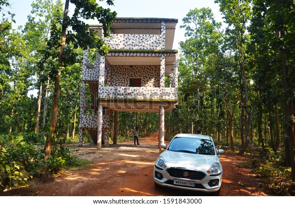 Bankura, West\
Bengal, India, 20 June 2019: A concrete elephant watch tower in the\
middle of a teak tree forest with green leaves and red mud of\
Bankura District of West Bengal,\
India