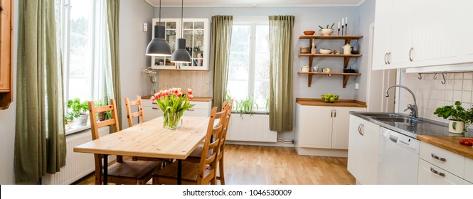 banner of acozy kitchen with tulips on the table and green curtains by the two windows