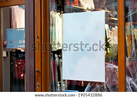 Banner for advertising in a shop window. Clothing store window with mannequins. Sign Board behind the glass. Copy space and space for text. Mockup for design. Blank template for advertising.