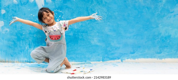 Banner Of Asian Little Girl Is Painting The Blue Color On The Wall And She Look Happy And Funny, Concept Of Art , Steam Education And Learn Through Play Activity For Kid Development.	