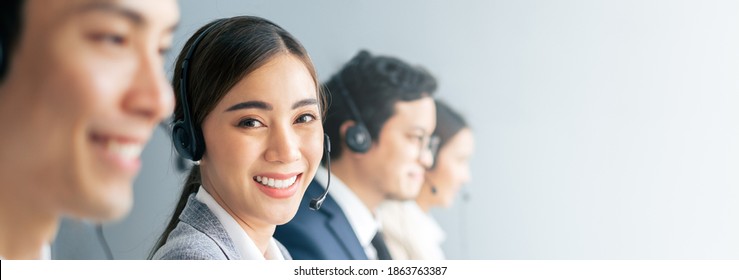 Banner Asian Team Call Center, Customer Service, Telesales In Casual With Headset Or Headphone And Look At Camera